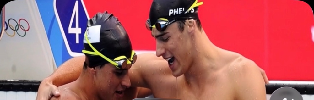 "Michael Phillips and Ryan enjoying time in a pool, smiling at the camera. The bright sun reflects off the water, creating a cheerful atmosphere." 
