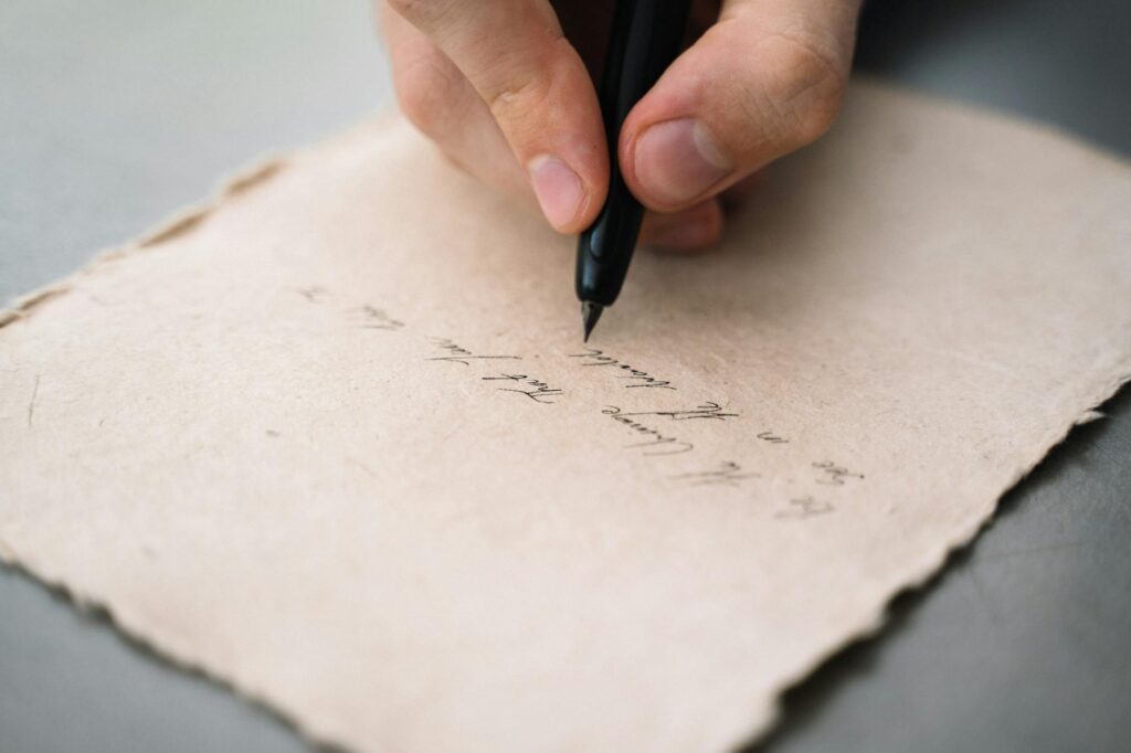 close up shot of a person writing on a paper